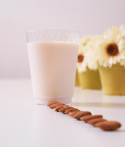 Almonds by glass of milk on table