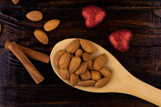 Almonds, cinnamon sticks and red shiny hearts. Top view, copy space.