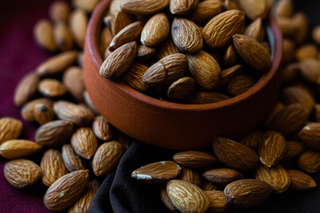 Almonds or dried fruit in a clay pot on a black cloth