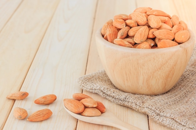 Almonds nut in wooden bowl on wooden table