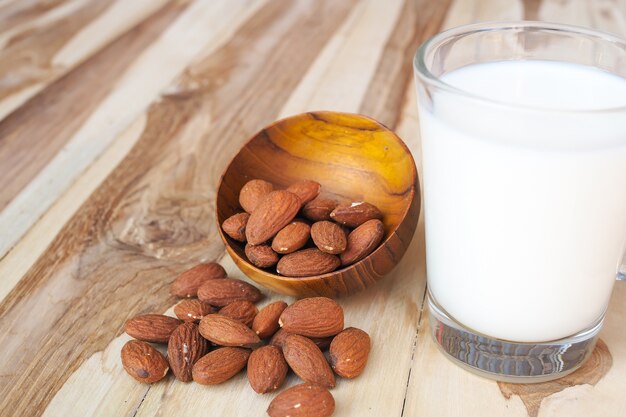 Almonds nuts and almond milk on wooden table