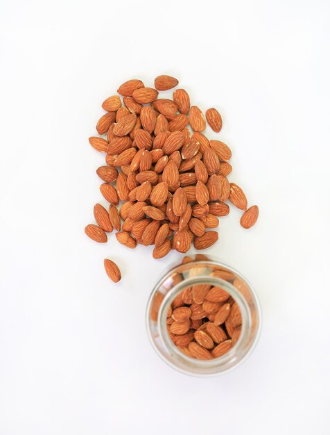 Almonds nuts and glass bottle isolated on a white background. Above view