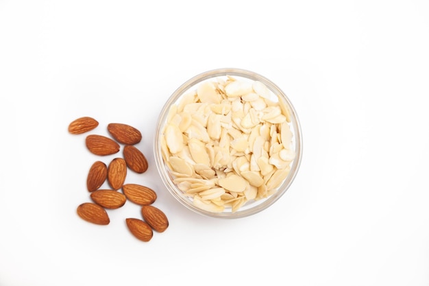 Миндальные орехи с лепестками в качестве ингредиента для кондитерских изделий крупным планом на белом фоне