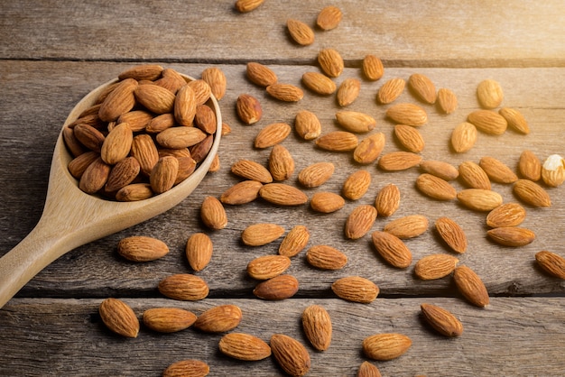 Photo almonds pour from wood spoon