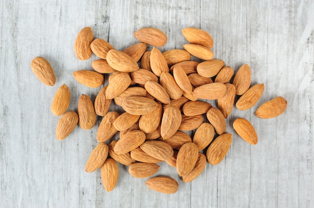 Almonds scattered over white stone board