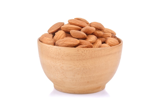 Almonds in wooden bowl isolated on white.