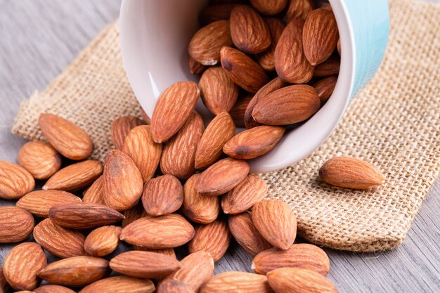 Almonds in a wooden bowl on the table. Almond concept with copy space.