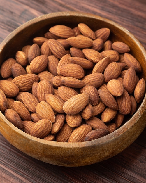 Almonds in wooden bowl on the table, Healthy snack, Vegetarian food.