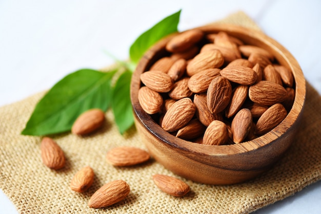 Almonds in a wooden bowl with leaves