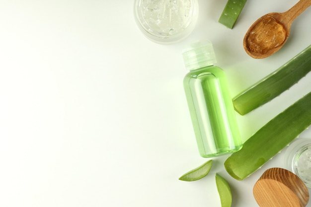 Aloe vera cosmetics, leaves and slices on white background