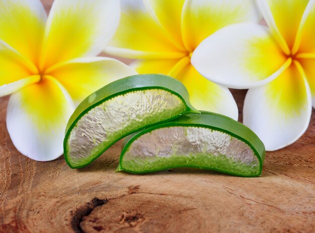 Aloe vera and frangipani flower on wooden