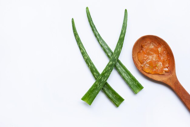 Aloe vera gel on wooden spoon with aloe vera on white background