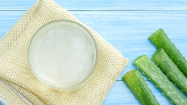 Aloe vera juice on a blue wooden table.