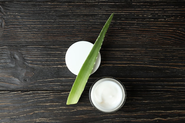 Aloe vera leaf and cream on wooden background