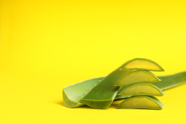 Aloe vera leaves and slices on yellow background