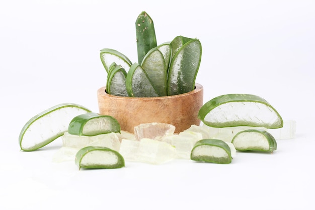 Aloe vera slices are placed in a wooden cup on a white background