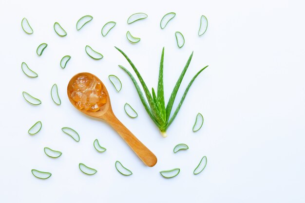 Aloe vera and slices with aloe vera gel on wooden spoon isolated on white 