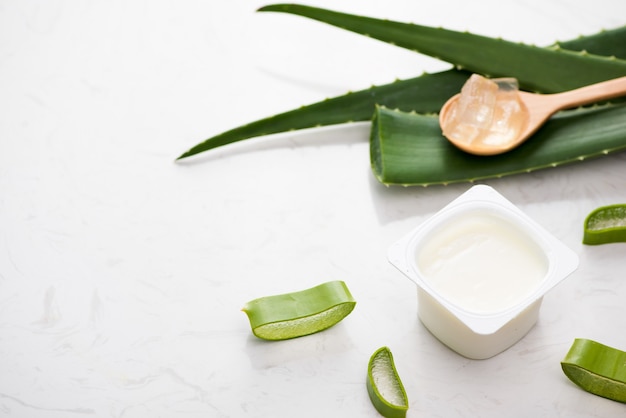 Aloe vera yogurt with fresh leaves on a wooden table