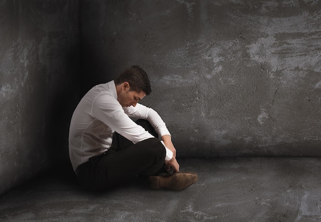 Alone desperate businessman sits on the floor. solitude and failure concept