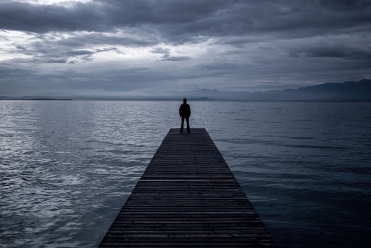 Photo alone man standing on a pier