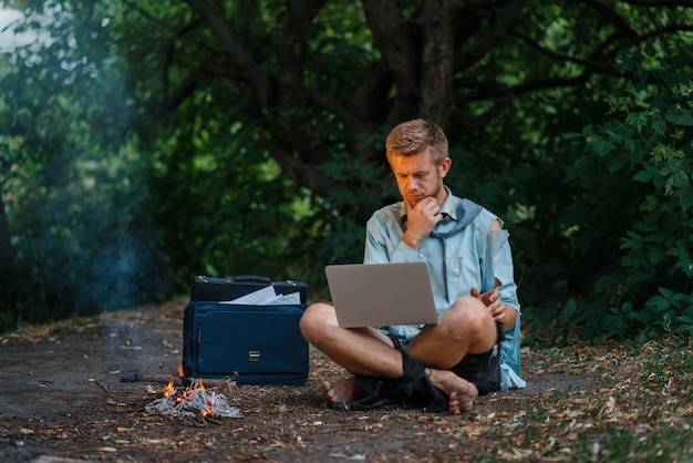 Alone office worker with laptop on desert island