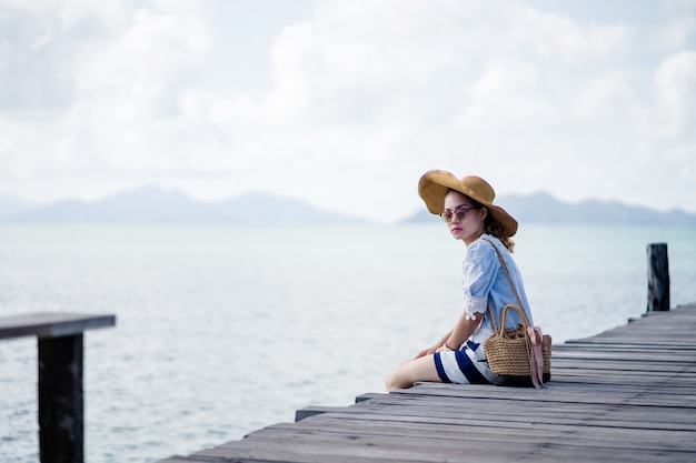 Photo an alone woman sitting on the wood bridge  - koh mark, thailand