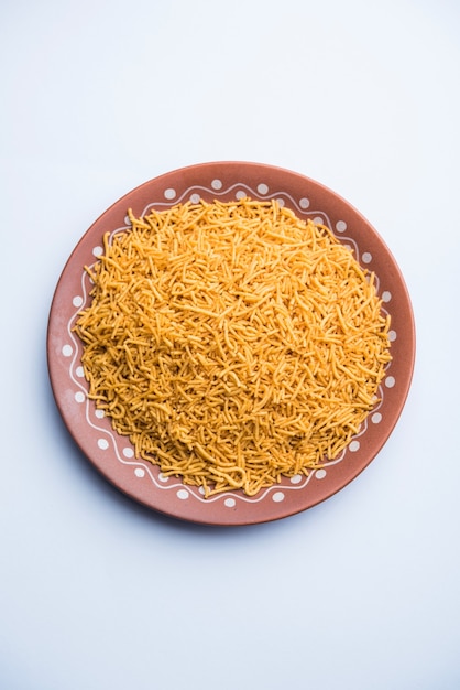 Алоо Бхуджия или Картофельная Бхуджиа, также известная как Намкин сев. Популярный рецепт биканери подается в миске или тарелке. выборочный фокус