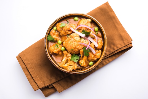 Aloo Gobi Mutter is een beroemd Indiaas currygerecht met aardappelen en bloemkool en groene erwten, selectieve focus