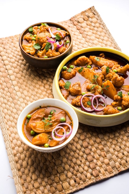 Aloo Gobi mutter is a famous Indian curry dish with potatoes and cauliflower and green peas, selective focus