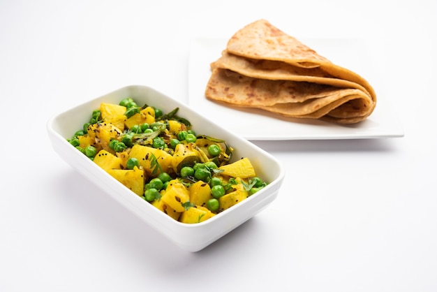 Aloo Mutter or Matar aalu dry sabzi, Indian Potato and green Peas fried together with spices and garnished with coriander leaves. served with roti or chapati