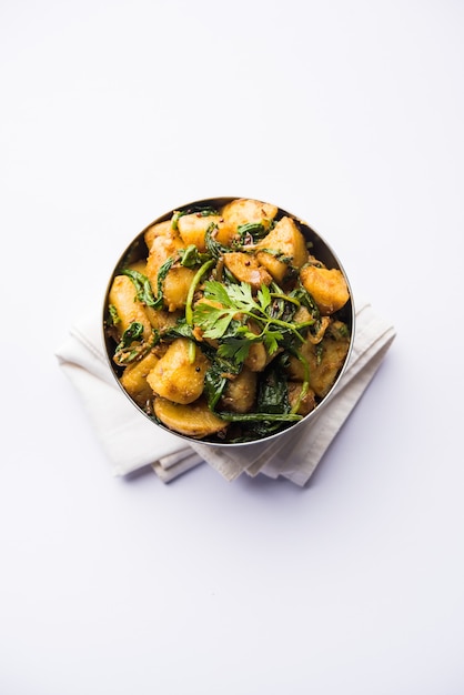 Aloo Palak sabzi - Aardappel gekookt met spinazie met toegevoegde kruiden. een gezond Indiaas hoofdgerecht recept. Geserveerd in een kom, selectieve focus