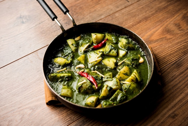 Алоо Палак сабзи или карри со шпинатом и картофелем, подаваемое в миске. Популярный индийский рецепт здорового питания. Выборочный фокус