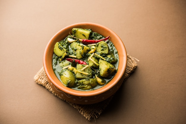Алоо Палак сабзи или карри со шпинатом и картофелем, подаваемое в миске. Популярный индийский рецепт здорового питания. Выборочный фокус