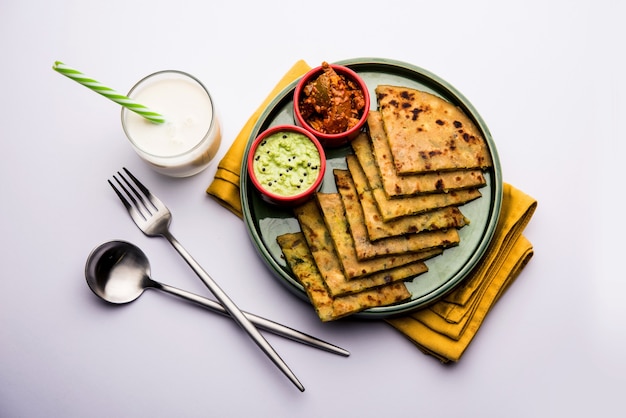 Aloo Paratha 또는 인도 감자 속을 채운 플랫브레드 위에 버터를 얹습니다. 신선하고 달콤한 라씨, 처트니, 피클과 함께 제공됩니다. 선택적 초점