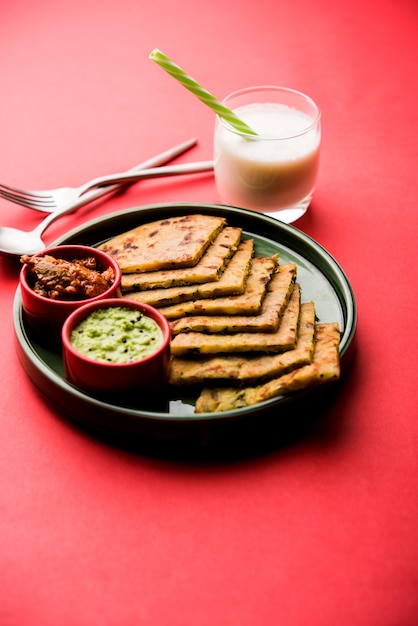 Aloo Paratha or Indian Potato stuffed Flatbread with butter on top. Served with fresh sweet Lassi, chutney and pickle . selective focus