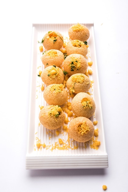 Aloo Sev Puri is a popular Indian roadside chat item, served in a white plate. Top view, selective focus