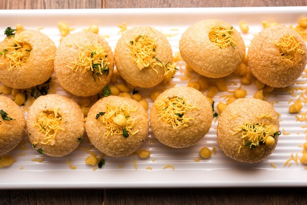 Aloo sev puri è un popolare oggetto di chiacchierata indiano lungo la strada, servito in un piatto bianco. vista dall'alto, messa a fuoco selettiva