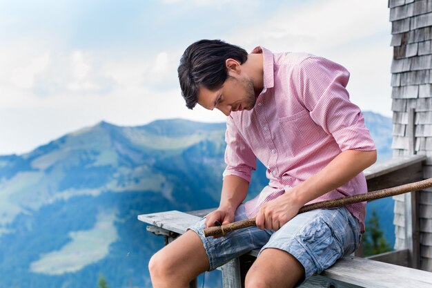 Alpen - Mens op bergen die bij cabine in Tirol zitten