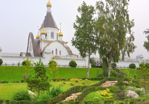 Alpentuin aan de voet van de tent Orthodoxe kerk achter het kloosterhek Krasnoyarsk