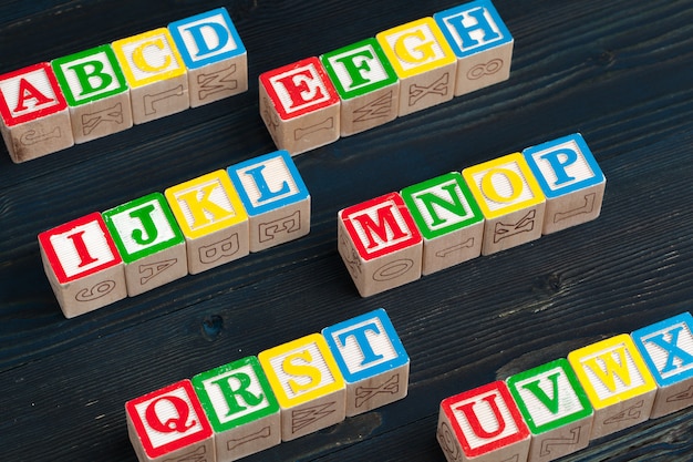 Alphabet blocks ABC on wooden table.