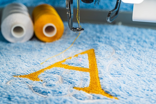 A alphabet design on towel in hoop of embroidery machine