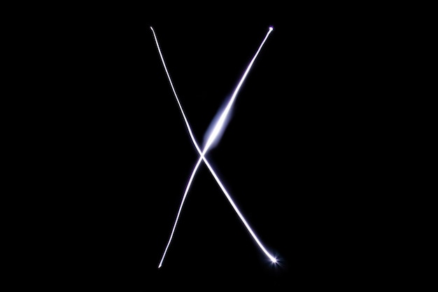 Alphabet made of neon light on a black background Isolated top view letter x