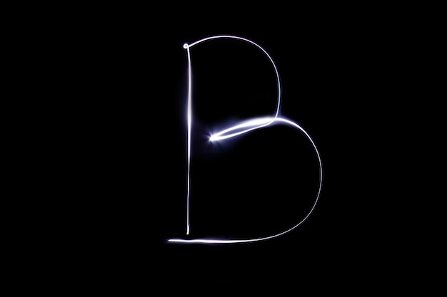 Фото Алфавит из неонового света на черном фоне изолированная буква b сверху