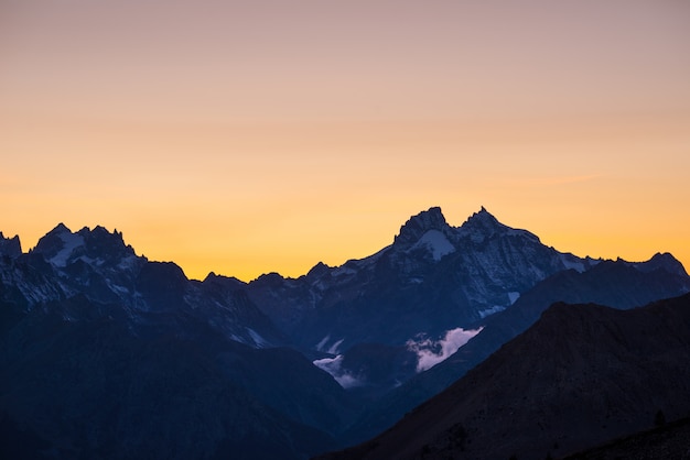 Alpien landschap op grote hoogte bij dageraad met eerste licht dat de majestueuze hoge piek van de Barre des Ecrins gloeit