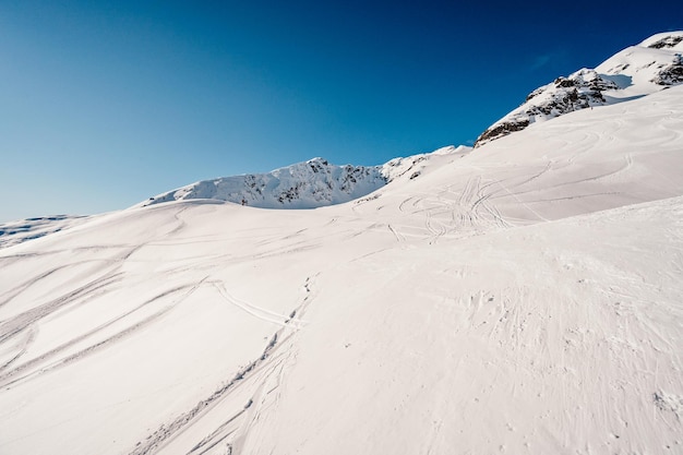 Alpine bergen landschap met witte sneeuw en blauwe lucht Zonsondergang winter in de natuur Ijzige bomen onder warm zonlicht Prachtig winters landschap