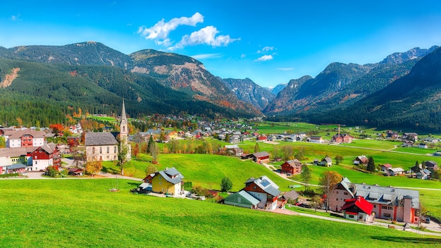 Alpine groene velden en traditionele houten huizen uitzicht op het dorp Gosau op zonnige herfstdag