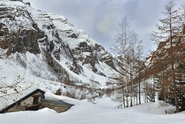 Alpine mountain in the snow with  a chalet burried in snow