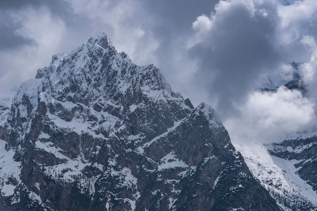 Alpine sneeuwpiek tegen een sombere hemel Dolomieten Italië lente in de bergen Het concept en idee van variabiliteit van het weer in de bergen