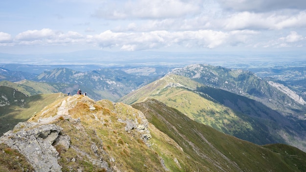 Alpine vista with mountain ranges and hiker going through them on a sunny day slovakia europe