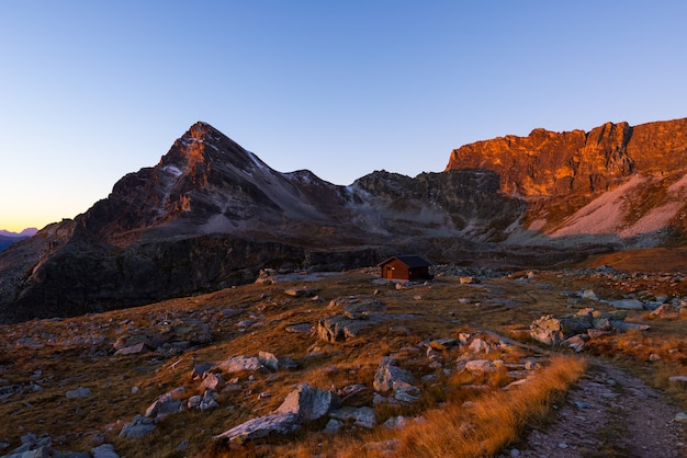 Alpine weide en grasland temidden van hoge hoogte bergketen bij zonsondergang